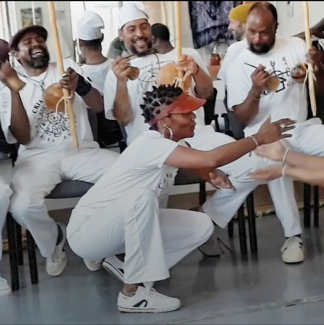 Capoeira Angola practitioners gathered in the roda, playing berimbaus and singing together